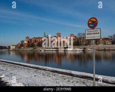 31/01/2021 - Polen/Krakau - Blick über die Weichsel und das Wawel-Schloss, die größte Attraktion Krakaus. Winterzeit. Schild, auf dem steht, dass man hier nicht schwimmen soll. Stockfoto