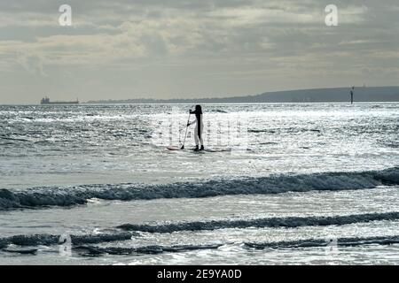 Einflügig Paddelboarder mit Sonnenlicht auf dem Wasser. Stockfoto
