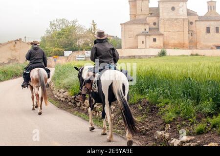 Reiter nähern sich der spanischen Stadt Casrojeriz, während sie auf Pferden entlang des Jakobswegs, dem Jakobsweg, reiten Stockfoto