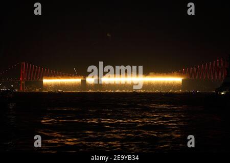 Feuerwerk über dem Istanbuler Bosporus während der Feierlichkeiten zum Tag der Türkischen Republik. Bosporus-Brücke mit roter Beleuchtung und Lasern bei Nacht. Stockfoto