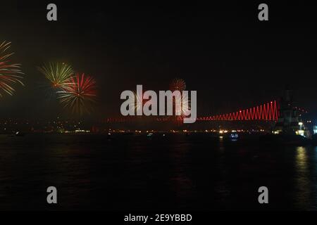 Feuerwerk über dem Istanbuler Bosporus während der Feierlichkeiten zum Tag der Türkischen Republik. Bosporus-Brücke mit roter Beleuchtung und Lasern bei Nacht. Stockfoto