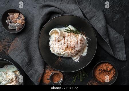 Vanilleeis mit Rosmarin und Kakao auf schwarzem Hintergrund. Stockfoto