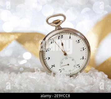 Countdown für Silvester. Fast Mitternacht auf einem alten Kreis silber glänzende Taschenuhr, Bokeh Hintergrund. Fünf Minuten vor zwölf. Feier, Party, Stockfoto