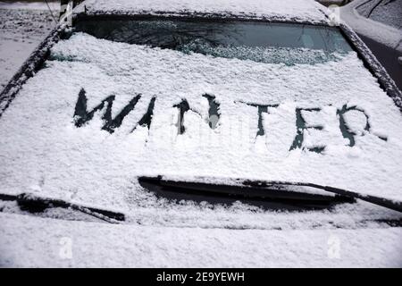 Der Gutsparkplatz im Winter. Die Inschrift: Winter auf einem schneebedeckten Autofenster gemacht. Stockfoto