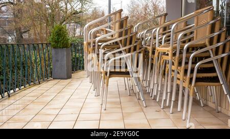 Retro-Stühle, Korbstühle, die während des Schließens in einem Stapel im geschlossenen Restaurant gestapelt wurden. Nahaufnahme. Stockfoto