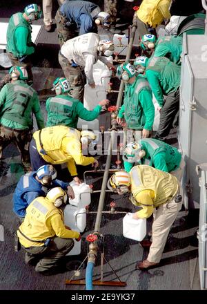 Besatzungsmitglieder an Bord der USS Abraham Lincoln (CVN 72) füllen Krüge mit gereinigtem Wasser aus einem Trinkwasserverteiler. Die Repair Division an Bord Lincoln baute den Verteiler in acht Stunden. Die Wasserkrüge werden mit Hubschraubern der Marine in vom Tsunami isolierte Regionen in Sumatra, Indonesien, geflogen. Hubschrauber, die Carrier Air Wing Two (CVW-2) zugewiesen wurden, und Matrosen von Abraham Lincoln unterstützen die Operation Unified Assistance, die humanitäre Operation nach dem Tsunami, der Südostasien heimsuchte. Foto von Cristina R. Morrison/USN via ABACA. Stockfoto