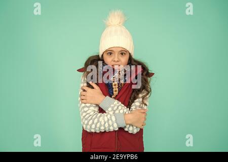 Jugend Straße Mode. In dieser Saison kalt fühlen. Kleiden Sie sich in Schichten und tragen Sie einen Hut. Bleiben Sie aktiv. Draußen ist es kalt. Warme Strickmode für Kinder. Wintervibes. Porträt des gefrorenen Mädchen-Hüpfers. Stockfoto