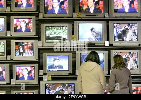 Kunden schauen sich am 25. Januar 2005 in einem Geschäft in Bordeaux, Südwestfrankreich, eine Wand mit Fernsehgeräten an. Digital Terrestrial Television (DTT) wird in Frankreich am 31. März 2005 verfügbar sein und bietet die ersten 13 freien Kanäle im ganzen Land. Vollständig über Erdkreise ausgestrahlt, kommt DTT über den Boden von einem nahe gelegenen VHF- oder UHF-Sender zum Benutzer und seine Signale werden über die gleichen Medien wie die analogen terrestrischen TV-Signale ausgestrahlt. Es bietet ein klareres Bild und eine überlegene Klangqualität im Vergleich zu analogen TV, mit weniger Störungen und bietet weit mehr Kanäle, so PR Stockfoto