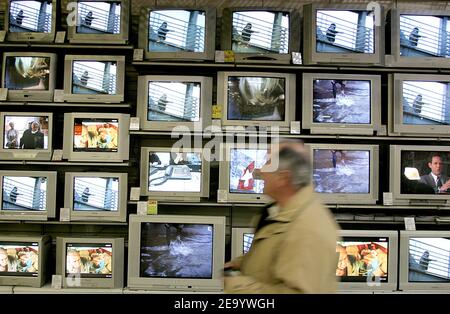 Ein Kunde schaut am 25. Januar 2005 in einem Geschäft in Bordeaux, Südwestfrankreich, auf eine Wand mit Fernsehgeräten. Digital Terrestrial Television (DTT) wird in Frankreich am 31. März 2005 verfügbar sein und bietet die ersten 13 freien Kanäle im ganzen Land. Vollständig über Erdkreise ausgestrahlt, kommt DTT über den Boden von einem nahe gelegenen VHF- oder UHF-Sender zum Benutzer und seine Signale werden über die gleichen Medien wie die analogen terrestrischen TV-Signale ausgestrahlt. Es bietet ein klareres Bild und eine hervorragende Klangqualität im Vergleich zu analogen Fernsehern, mit weniger Störungen und bietet somit weit mehr Kanäle Stockfoto