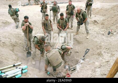 US-Marineinfanteristen entfernen am 3. März 2005 einen von mehreren Fällen von Kampfmitteln, die in einem Waffenlager außerhalb von Kharma, Irak, gefunden wurden. Die Marineinfanteristen stammen aus dem Bataillon der Kampfingenieure von 2nd, das dem Bataillon von 3rd und dem Marine-Regiment von 8th angehängt ist und in der irakischen Provinz Al Anbar in Sicherheits- und Stabilisierungsoperationen tätig sind. DoD-Foto von CPL. Trevor R. Gift, U.S. Marine Corps. Foto von Trevor R. Gift/DOD/ABACA Stockfoto