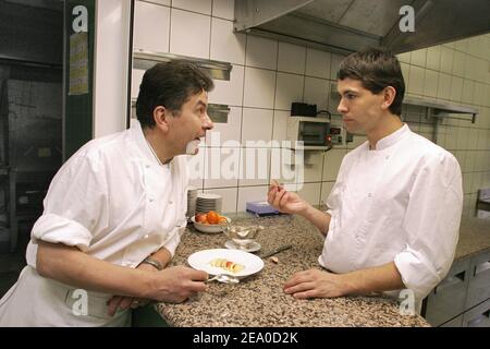 EXKLUSIV. Der französische Dreisternekoch Regis Marcon (L) und sein Sohn Jacques diskutieren am 22. März 2005 in der Küche seines Restaurants 'Le Clos des Cimes' in Saint-Bonnet-le-Froid, Zentralfrankreich, einen neuen Empfang. Marcon erhielt gerade seinen dritten Stern, der 2005 vom Guide Michelin ausgezeichnet wurde. Foto von Alexis Orand/ABACA. Stockfoto