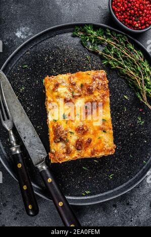 Lasagne mit Hackfleisch Rindfleisch und Tomate Bolognese Sauce auf einem Teller. Schwarzer Hintergrund. Draufsicht Stockfoto