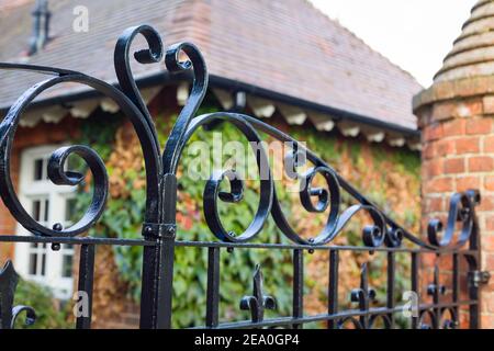 Schmiedeeiserne Tore aus der Nähe, geschlossene schwarze Metalltore zu einem Landhaus, Großbritannien Stockfoto