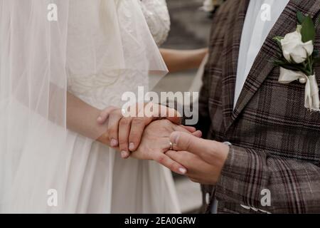 Das Brautpaar berührt sich gegenseitig mit den Händen. Liebe und Zärtlichkeit. Werbung für Hochzeitsagentur