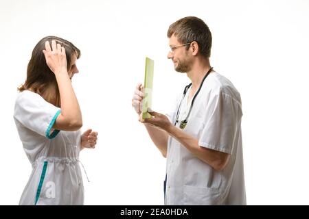 Der Praktikant denkt über die Frage nach dem Tablet nach Computer vom Arzt gezeigt Stockfoto