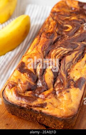 Hausgemachtes Schokoladen-Bananenbrot auf rustikalem Holzbrett, Blick in den unteren Winkel. Nahaufnahme. Stockfoto