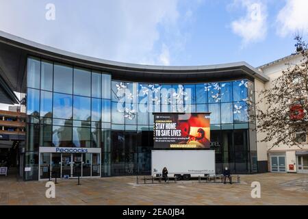 Beleuchtete Tafel mit COVID-19 Lockdown 'Stay Home to Save Lives' Botschaft in Jubilee Square, Woking Stadtzentrum, Surrey, Südostengland Stockfoto