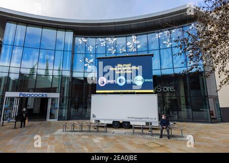 Beleuchtete Tafel mit COVID-19 Lockdown 'Hände, Gesicht, Raum' Nachricht in Jubilee Square, Woking Stadtzentrum, Surrey, Südostengland Stockfoto