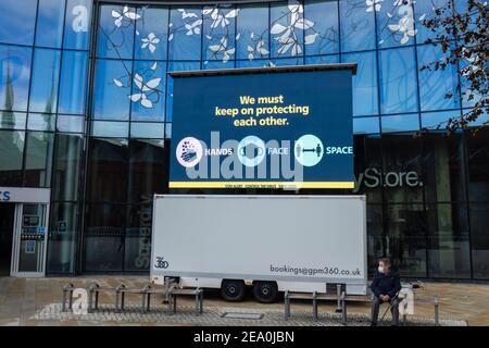 Beleuchtete Tafel mit COVID-19 Lockdown 'Hände, Gesicht, Raum' Nachricht in Jubilee Square, Woking Stadtzentrum, Surrey, Südostengland Stockfoto