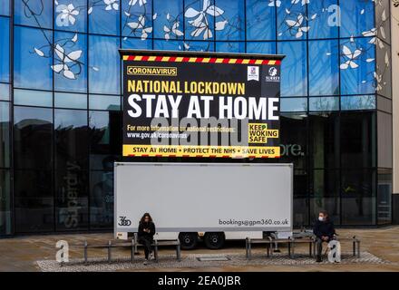 Beleuchtetes Tafelschild mit COVID-19 Lockdown Nachrichten in Jubilee Square, Woking Stadtzentrum, Surrey, Südostengland Stockfoto