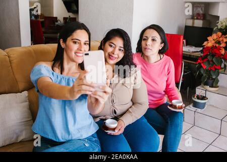 Latin Girls Spaß zu Hause machen Selfie Foto, lachen und trinken Kaffee in Mexiko-Stadt Stockfoto