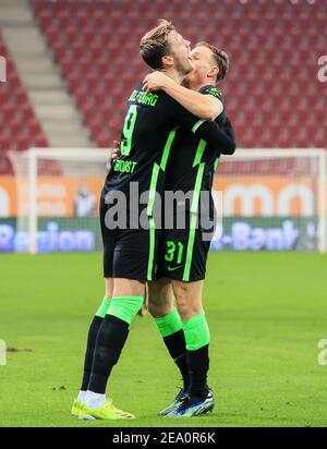 Augsburg, Deutschland. Februar 2021, 6th. Wout Weghorst (L) aus Wolfsburg feiert seinen Torschuss mit Teamkollege Yannick Gerhardt bei einem Bundesligaspiel zwischen FC Augsburg und VfL Wolfsburg in Augsburg, Deutschland, 6. Februar 2021. Quelle: Philippe Ruiz/Xinhua/Alamy Live News Stockfoto