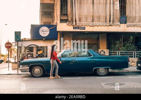 Eine Frau geht an einem klassischen Cadillac Coupe DeVille in Beirut, Libanon, vorbei Stockfoto