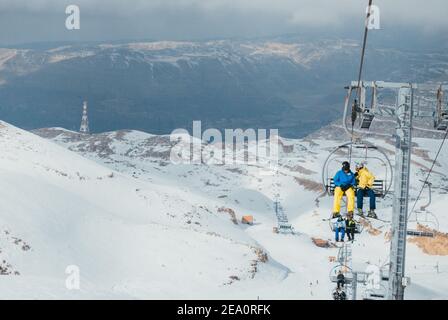 Skifahrer auf dem Sessellift im Skigebiet Mzaar Kfardebian im Libanon, dem größten Wintersportort im Nahen Osten Stockfoto