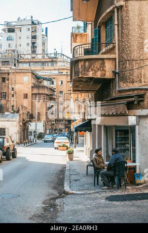 Zwei Männer sitzen in einem Eckcafé in einer Innenstadtstraße in Beirut, Libanon Stockfoto