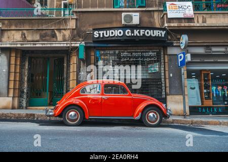 Ein leuchtend roter klassischer Volkswagen Beetle, der auf einer Stadtstraße in Beirut, Libanon, geparkt ist Stockfoto