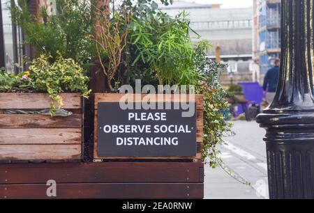 Schild „Please observe Social Distancing“ in Covent Garden, London. Stockfoto