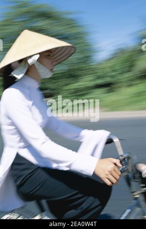 Asien, Vietnam, Mekong Delta, hübsche junge Schülerinnen tragen traditionelle vietnamesische AOI- Dai Kleid Radfahren zur Schule Stockfoto