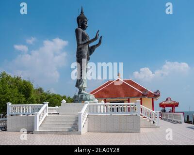 Stehende Buddha-Statue im Wat Khun Samut Chin, einem buddhistischen Tempel in der Provinz Samut Prakan in Thailand. Der Tempel ist durch das Meer umgeben Stockfoto