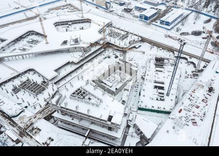Luftaufnahme der städtischen Baustelle mit Arbeitskränen in Winterzeit Stockfoto