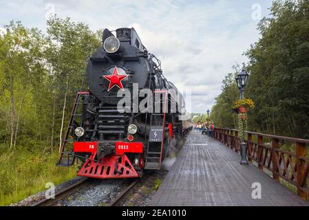 RUSKEALA, RUSSLAND - 15. AUGUST 2020: Touristenzug 'Ruskeala Express' auf dem Bahnsteig des Bahnhofs Ruskeala an einem bewölkten Augusttag Stockfoto