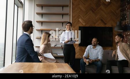 Junge indische weibliche halten Tablet-pc sprechen auf Mitarbeitertreffen Stockfoto