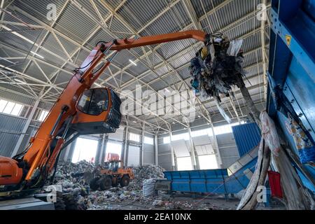 Abfallsortierungs- und Recycling-Anlage. Ladekran und Greifkran handhaben Abfall. Stockfoto