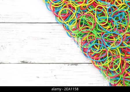 Bunte Gummibänder auf einem weißen Holztisch Stockfoto