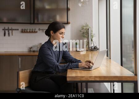 Indische Frau suchen Informationen im Internet auf Laptop zu Hause Stockfoto