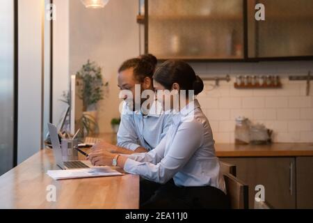 Diverse Kollegen diskutieren Arbeit per Laptop im Büro-Essbereich Stockfoto