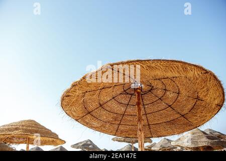 Strohschirme am Strand gegen den Himmel Stockfoto