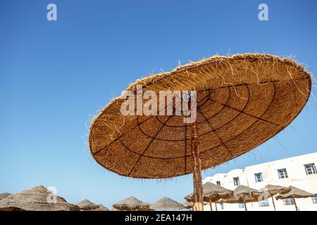 Strohschirme am Strand gegen den Himmel Stockfoto