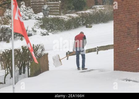 Haltern, NRW, Deutschland. Februar 2021, 07th. Ein Mann wird gesehen, wie er Schnee schaufelt, um den Weg zu einem Haus zu räumen. In Nordrhein-Westfalen und anderen Teilen Deutschlands gibt es nach Stürmen eine Unwetterwarnung, bis zu 30cm Schnee fielen über Nacht und am Sonntagmorgen. Das Unwetter wird sich fortsetzen. Kredit: Imageplotter/Alamy Live Nachrichten Stockfoto