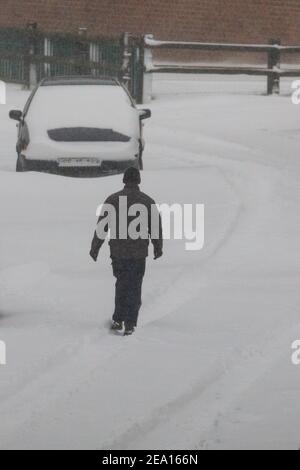 Haltern, NRW, Deutschland. Februar 2021, 07th. Ein Mann geht durch den Neuschnee. In Nordrhein-Westfalen und anderen Teilen Deutschlands gibt es nach Stürmen eine Unwetterwarnung, bis zu 30cm Schnee fielen über Nacht und am Sonntagmorgen. Das Unwetter wird sich fortsetzen. Kredit: Imageplotter/Alamy Live Nachrichten Stockfoto