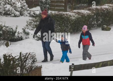 Haltern, NRW, Deutschland. Februar 2021, 07th. Eine Familie hat sich warm eingewickelt, um durch den Schnee zu schlendern. In Nordrhein-Westfalen und anderen Teilen Deutschlands gibt es nach Stürmen eine Unwetterwarnung, bis zu 30cm Schnee fielen über Nacht und am Sonntagmorgen. Das Unwetter wird sich fortsetzen. Kredit: Imageplotter/Alamy Live Nachrichten Stockfoto