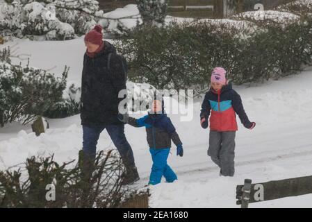 Haltern, NRW, Deutschland. Februar 2021, 07th. Eine Familie hat sich warm eingewickelt, um durch den Schnee zu schlendern. In Nordrhein-Westfalen und anderen Teilen Deutschlands gibt es nach Stürmen eine Unwetterwarnung, bis zu 30cm Schnee fielen über Nacht und am Sonntagmorgen. Das Unwetter wird sich fortsetzen. Kredit: Imageplotter/Alamy Live Nachrichten Stockfoto