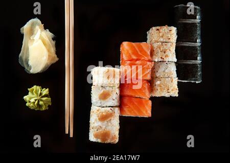 Food Hintergrund Set Sushi-Rolle mit Lachs. Sushi-Menü. Japanisches Essen. Schwarzer Hintergrund. Draufsicht. Lebensmittellieferungscoronavirus. Stockfoto