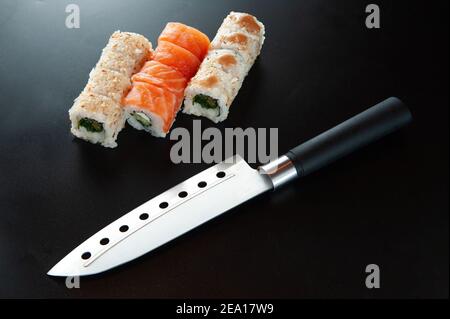 Sushi mit Messer auf dunklem Hintergrund. Stockfoto