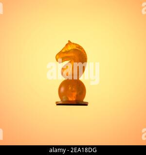 Bernsteinfarbenes Schachset, Schachfigur White Knight auf goldfarbenem Hintergrund. Stockfoto