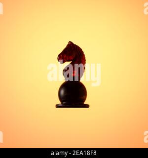 Bernstein Schachset, Schachfigur Black Knight auf Gold Gradienten Hintergrund. Stockfoto